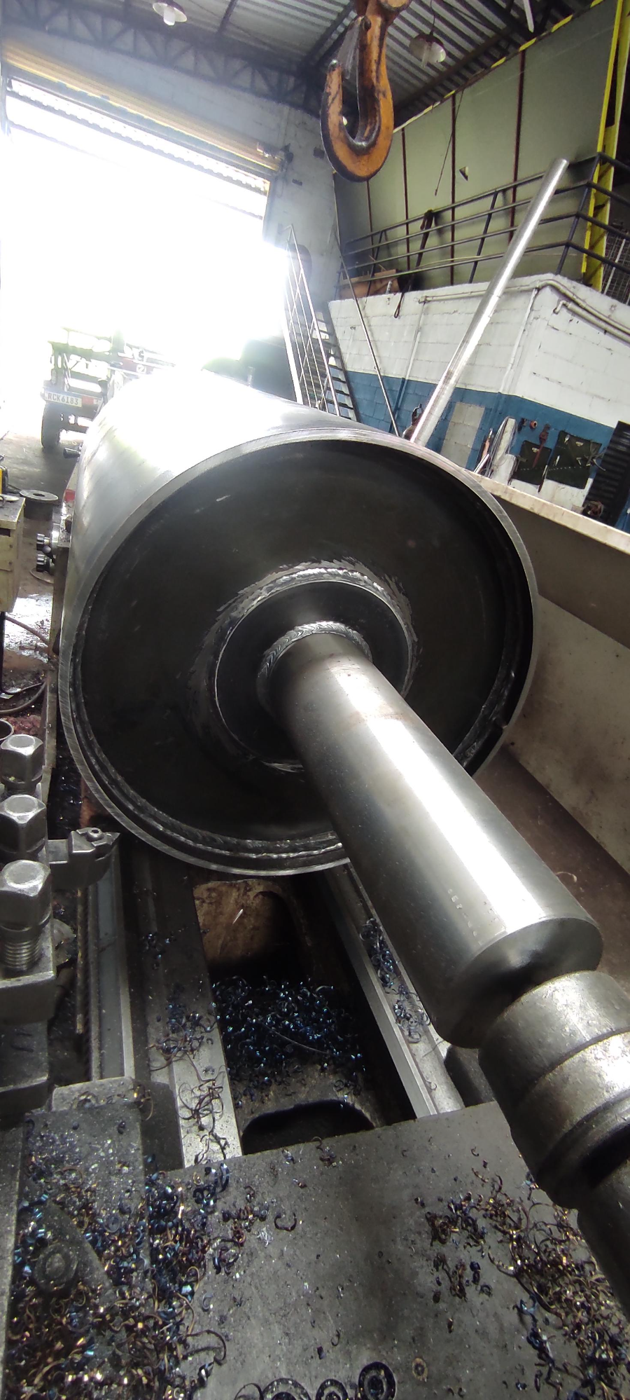 Manutenção de rolo industrial em torno mecânico